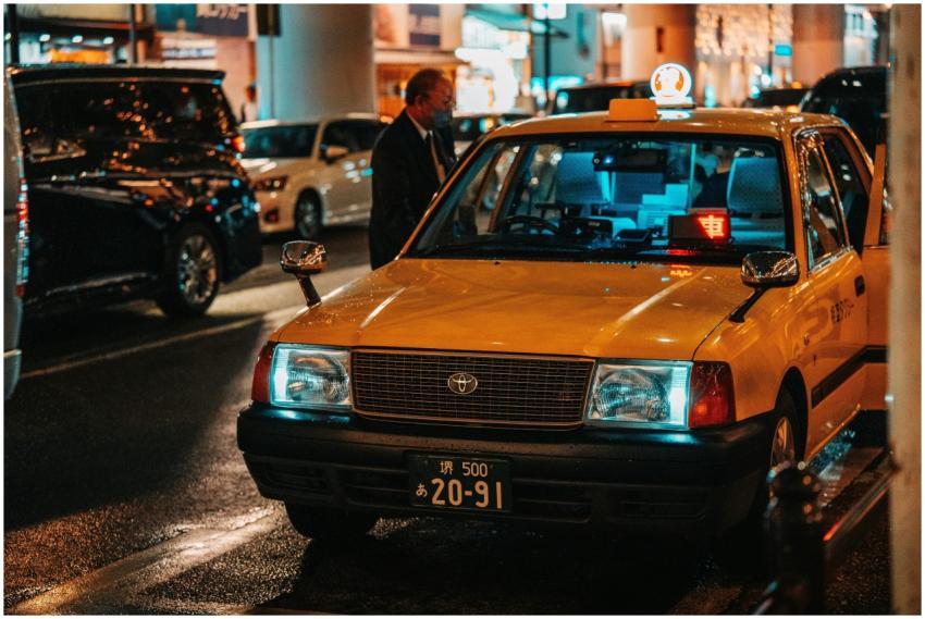 A vibrant night scene of a yellow taxi in Dotonbor