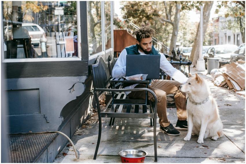 Man working remotely on his laptop outside with hi