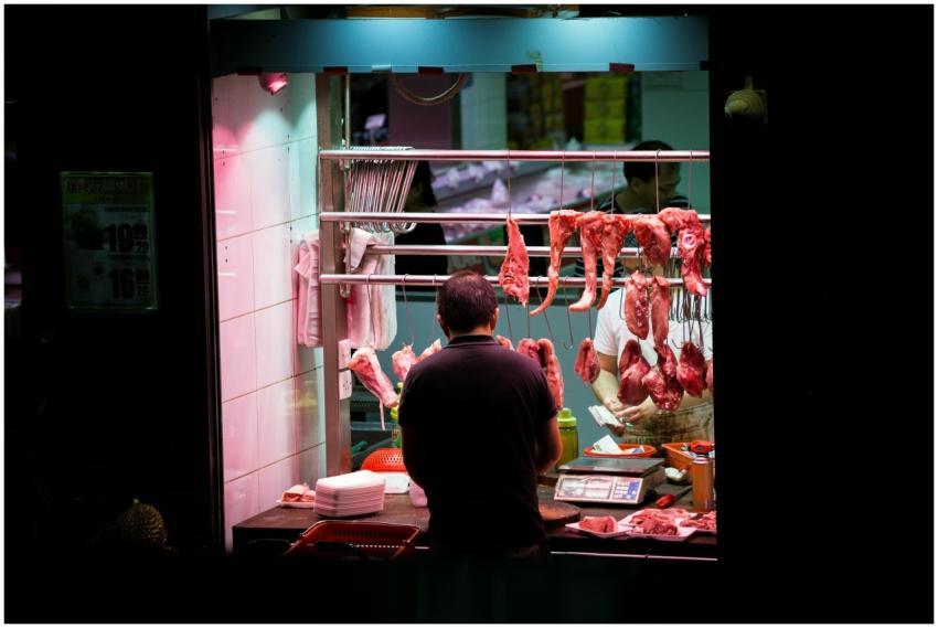 Butcher working in a vibrant Hong Kong market stal