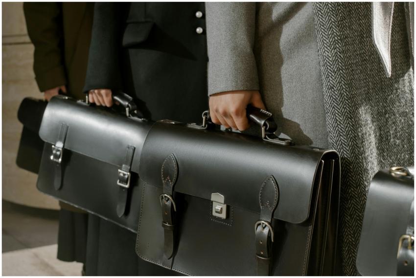 Group of adults holding sleek leather briefcases i