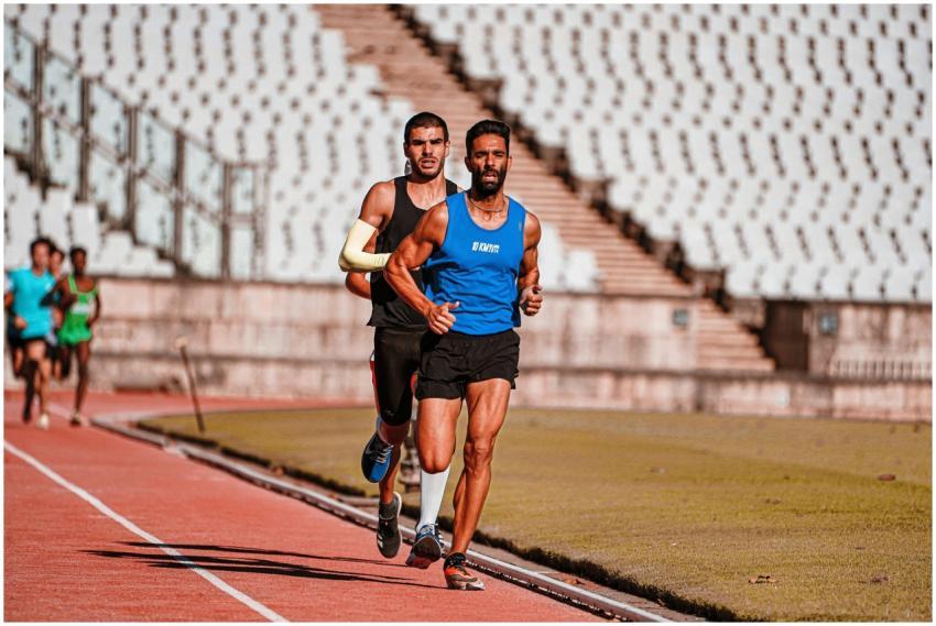 Focused male runners competing on a sports track d