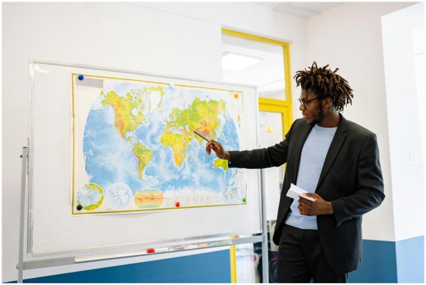 Teacher pointing at world map during classroom les