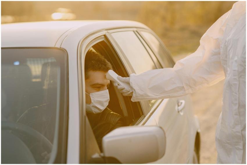 Healthcare worker in protective suit uses a therma