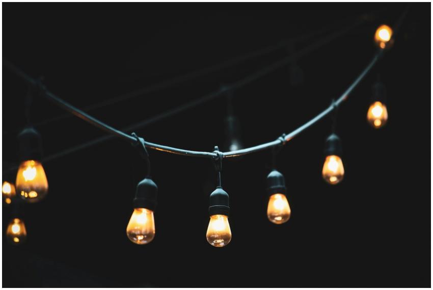 Close-up of glowing string lights against a dark b