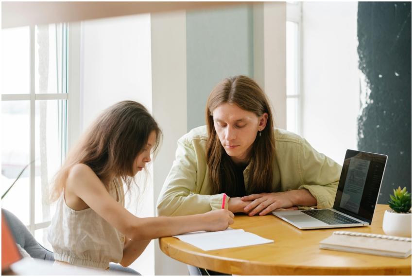 A father helps his daughter with homeschooling ind