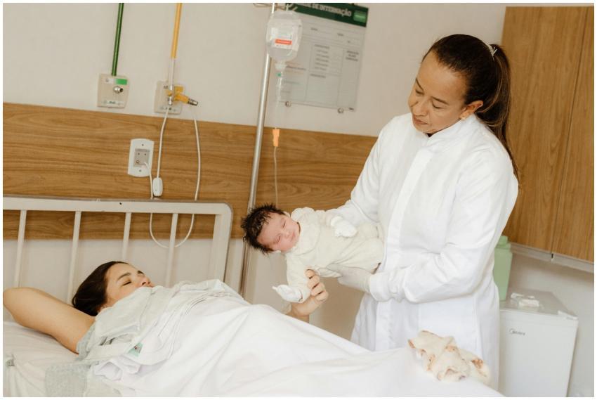 A doctor assists a new mother with her newborn bab