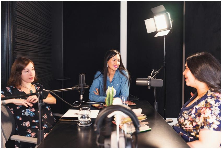 Three women engaged in a lively podcast discussion
