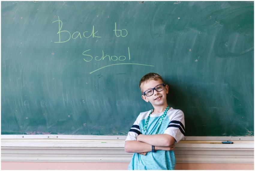 A young boy stands confidently with folded arms in