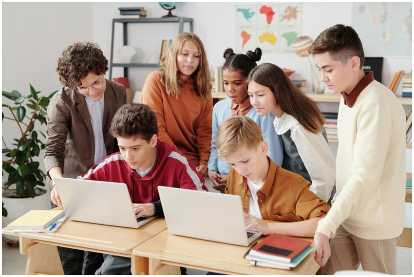 A group of diverse students collaborating on lapto