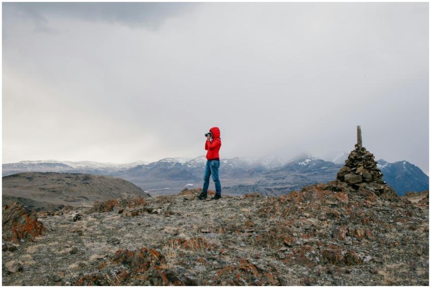 A solitary explorer in a red jacket surveys a stun