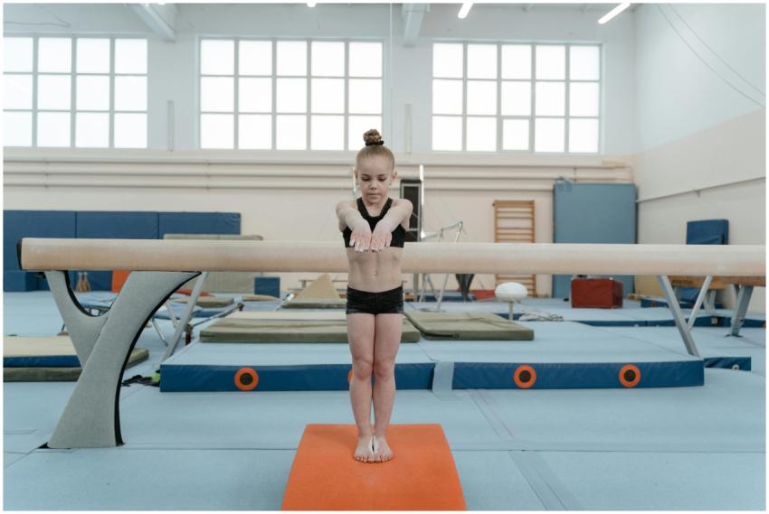 A young girl focuses while performing a balance be