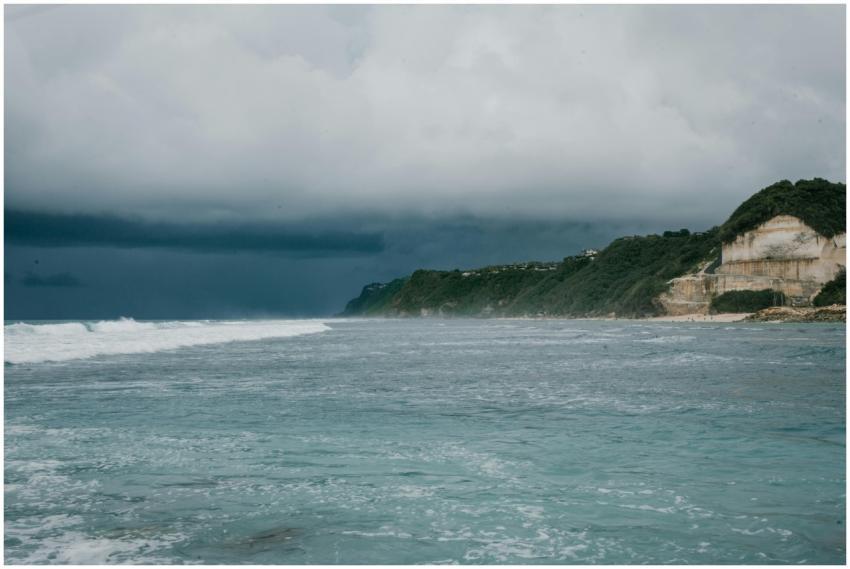 A scenic view of a cloudy coastline with dramatic