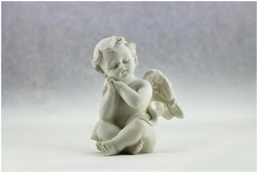 A cute ceramic angel figurine in a serene pose, pe