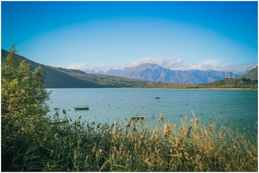 Tranquil landscape of a lake, mountains, and blue