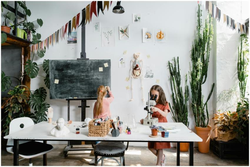 Two young girls explore science with a microscope