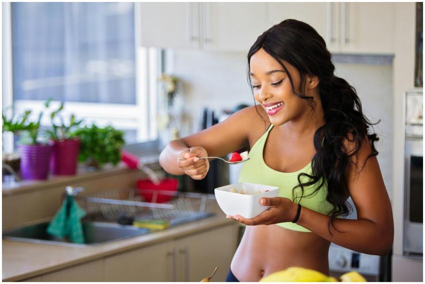 Cheerful woman enjoying fresh strawberries in a co