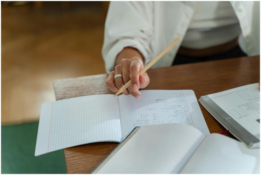 Close-up of a person writing in a graph notebook w