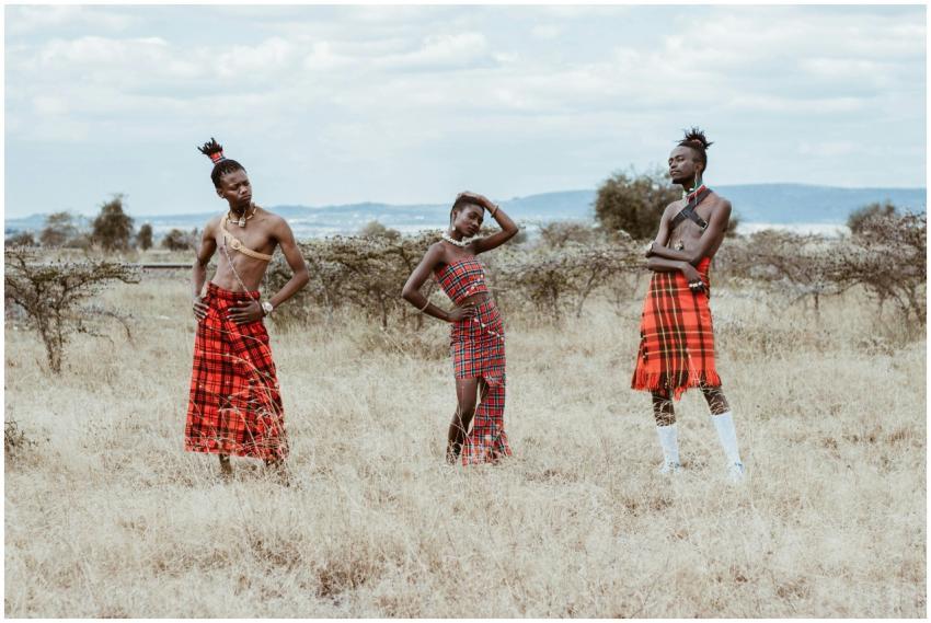 Three people in traditional tribal attire posing i