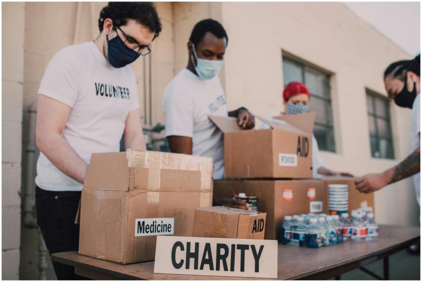 Group of volunteers wearing masks organizing donat