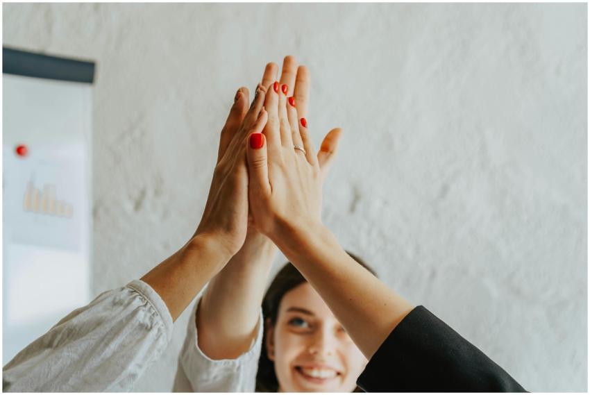 A close-up of a group high five, representing team