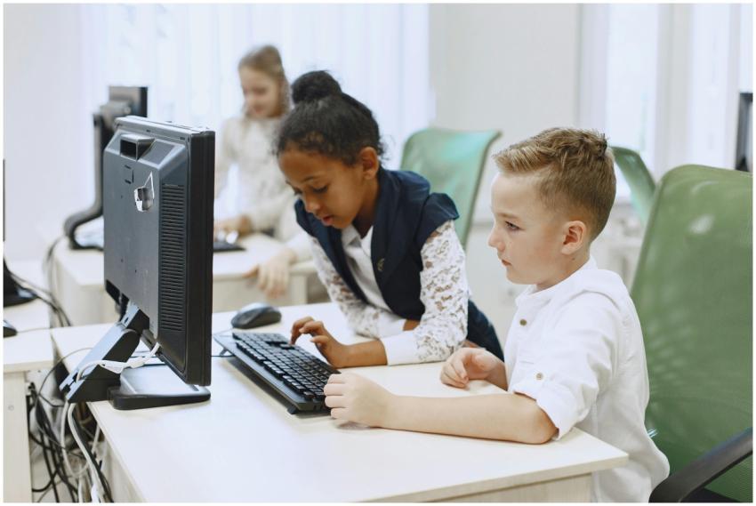 Diverse children working together on computers in