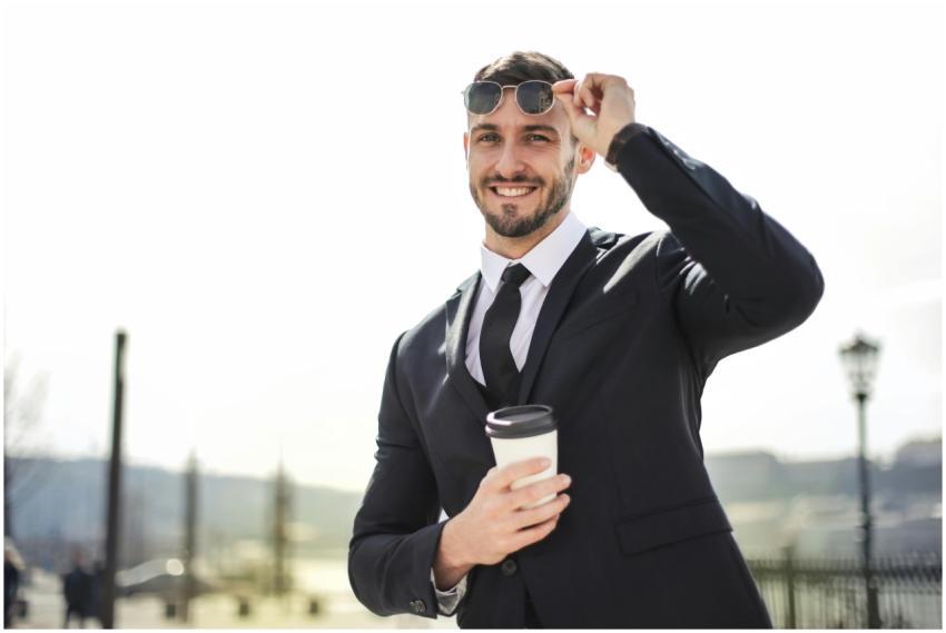 Smiling businessman in formal attire with coffee c