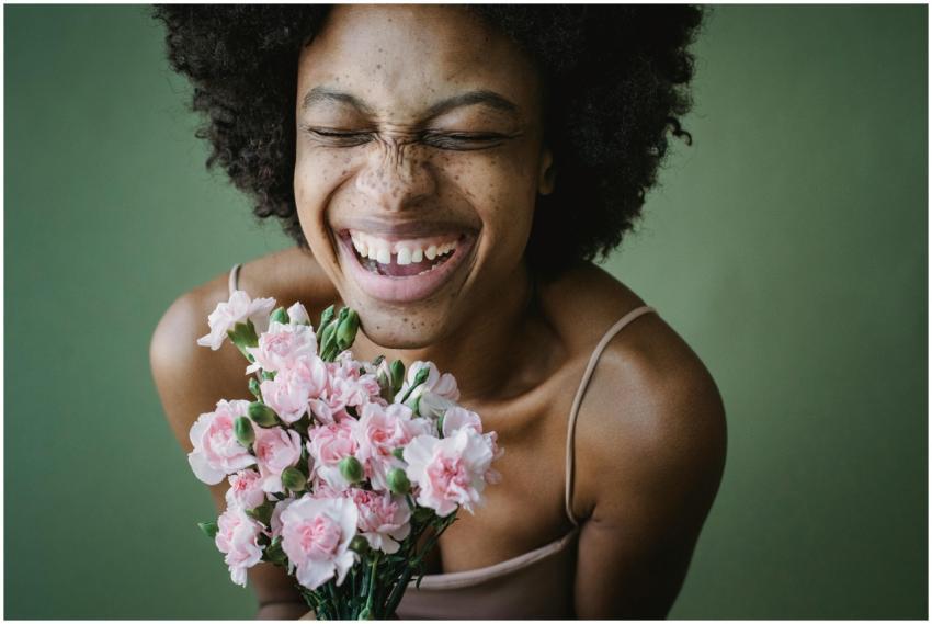 A cheerful woman with a radiant smile holding a pi