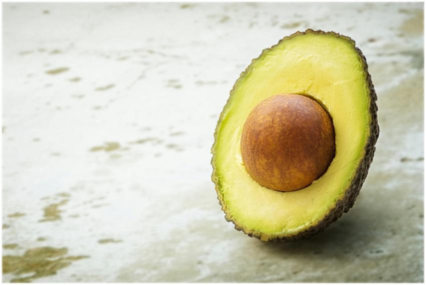 Close-up of a ripe avocado half with seed, showcas