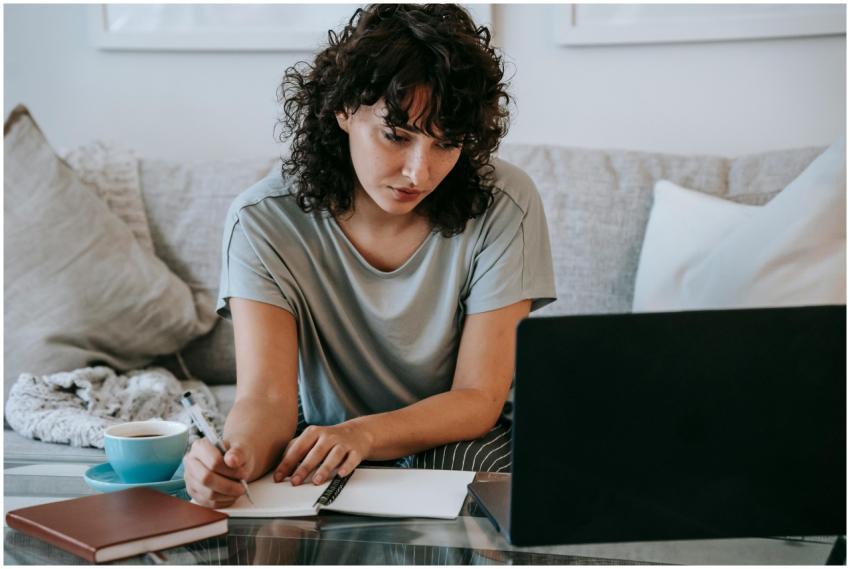 Young woman concentrating on study at home with la