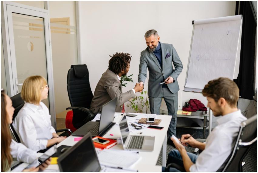 Colleagues shake hands during a corporate meeting,