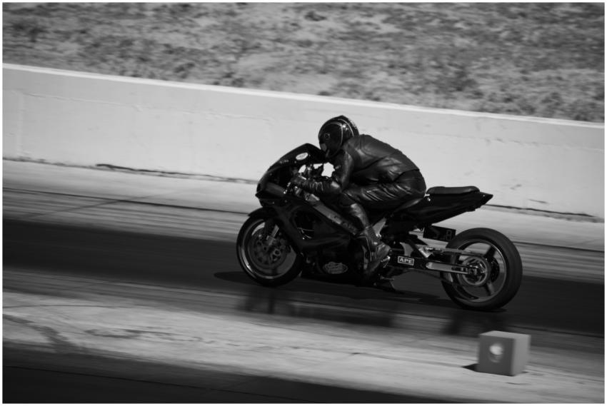 Black and white photograph capturing a motorcyclis