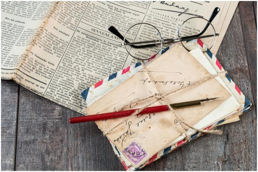 Close-up of old letters, an ink pen, and vintage g