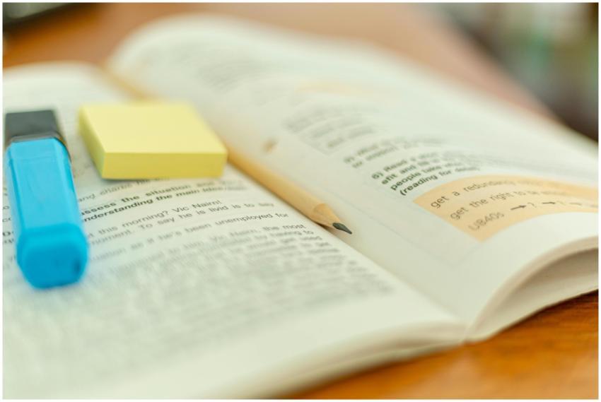 Close-up of an open book with a highlighter and st