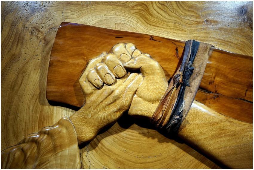 Detailed wooden sculpture depicting clasped hands,
