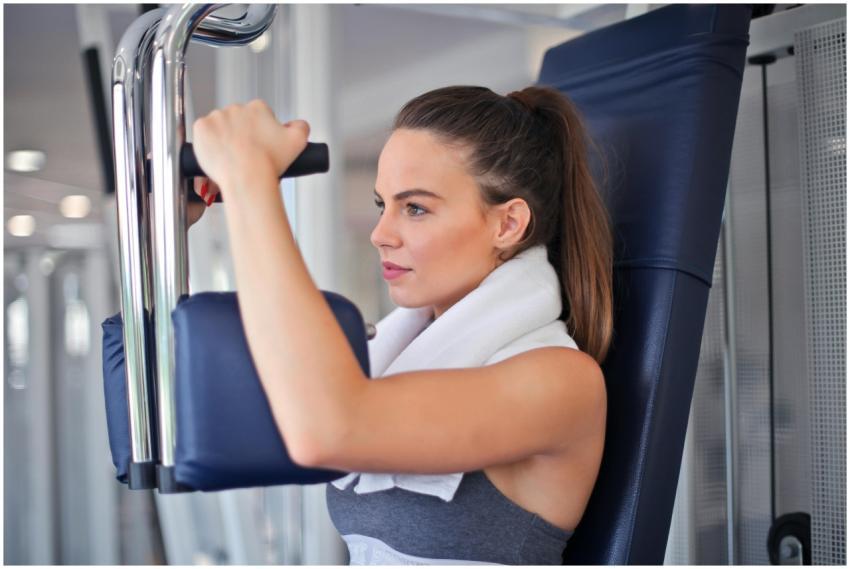 Young woman working out on a chest press machine i
