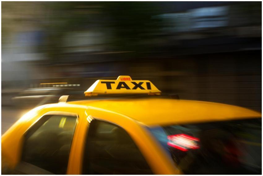 A vibrant yellow taxi with motion blur speeding th