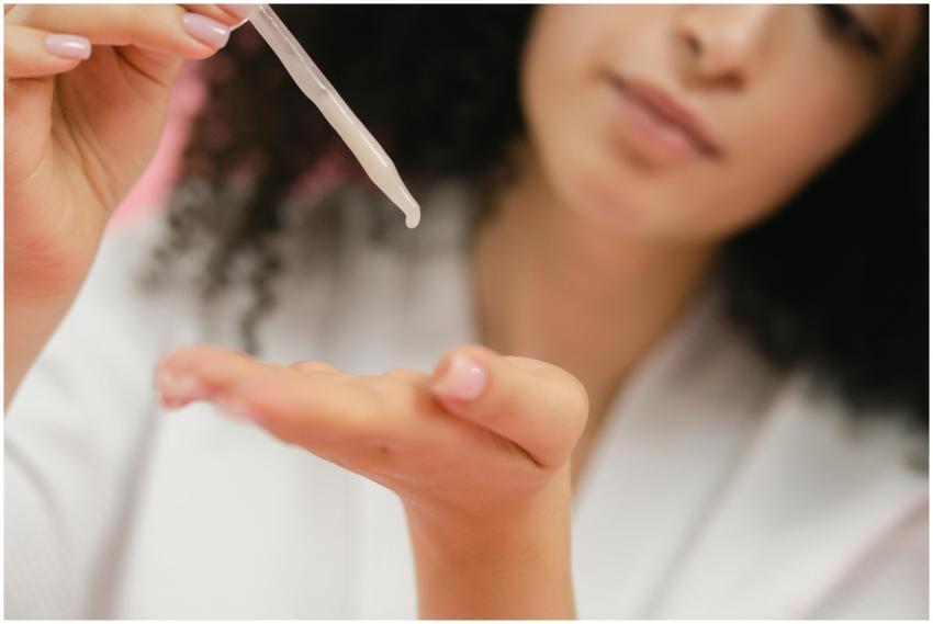 Close-up of a woman applying skincare serum with a