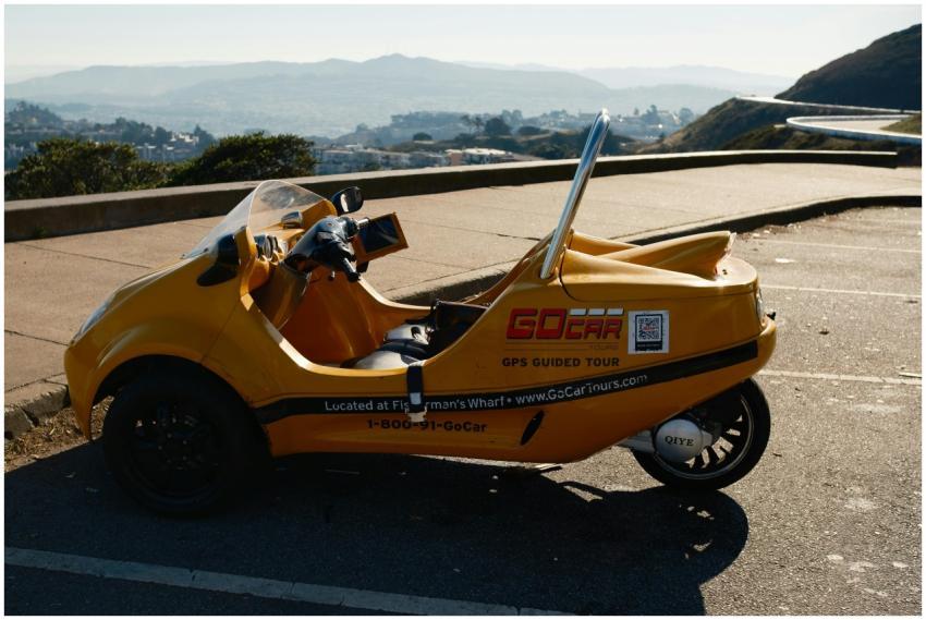 A vibrant yellow GoCar parked with a scenic view i