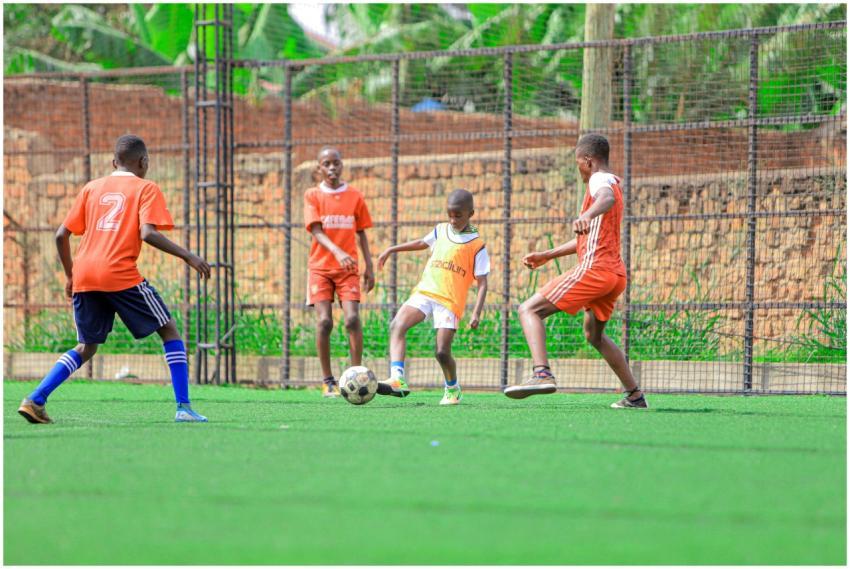Group of boys playing soccer on an outdoor field,