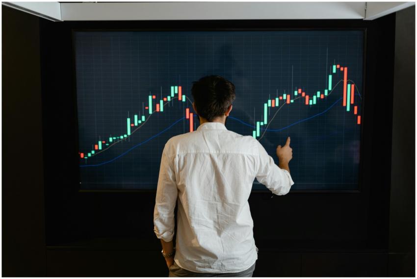 Adult male reviewing stock market data on a large
