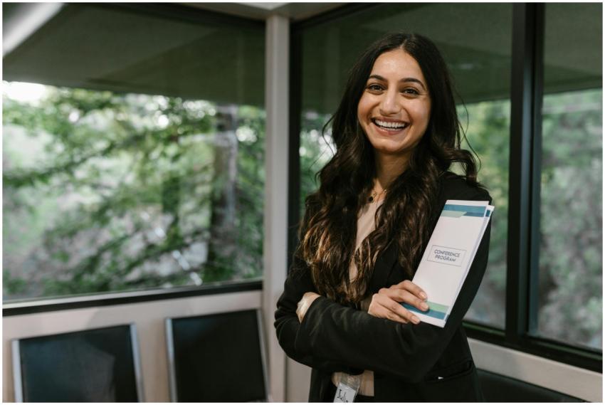 Confident woman holding conference program, smilin