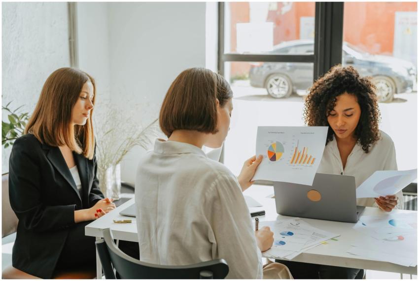 Three women engaged in a business meeting, discuss