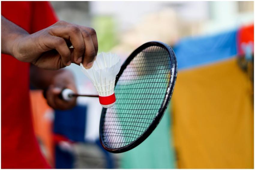 Close-up of a hand holding a shuttlecock and badmi