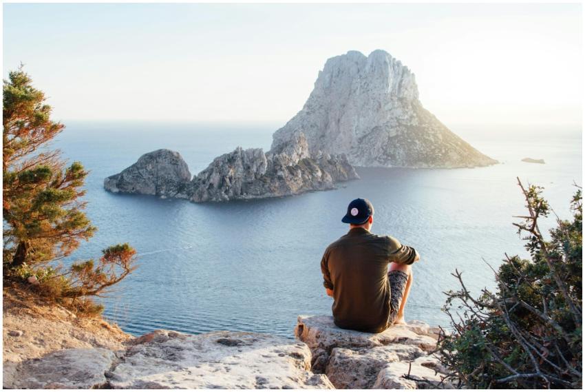 Man enjoys a scenic view of Es Vedrà at sunset fro