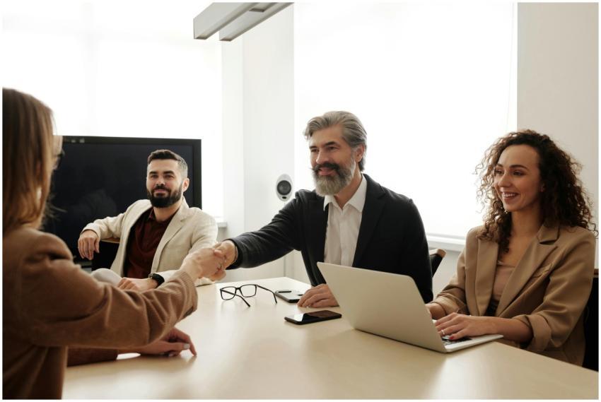 A group of business professionals shake hands duri