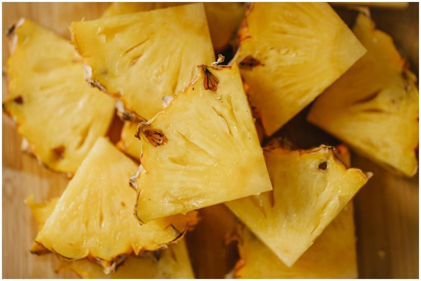 Overhead view of juicy pineapple slices on a woode