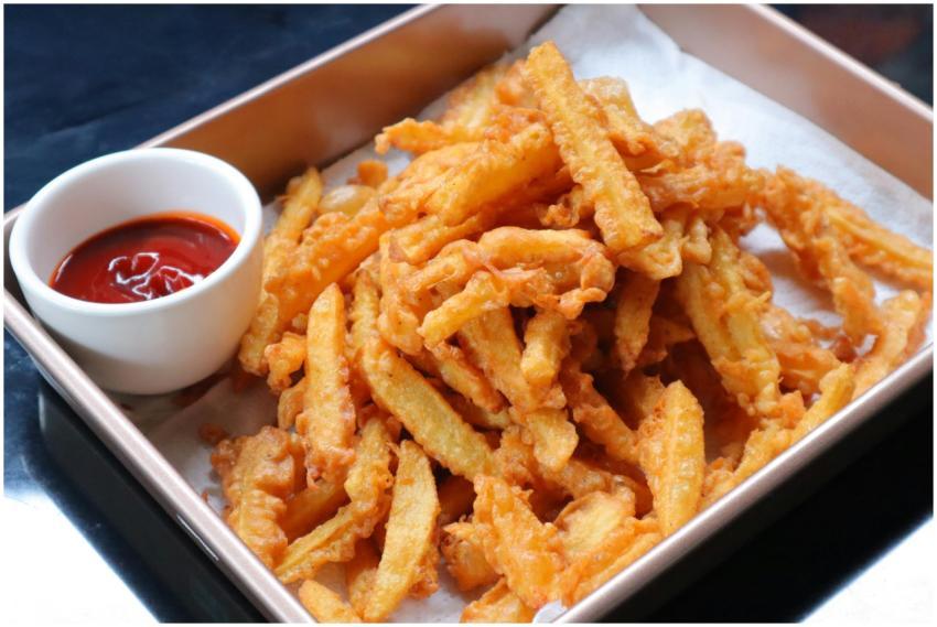 Close-up of golden crispy french fries with a side