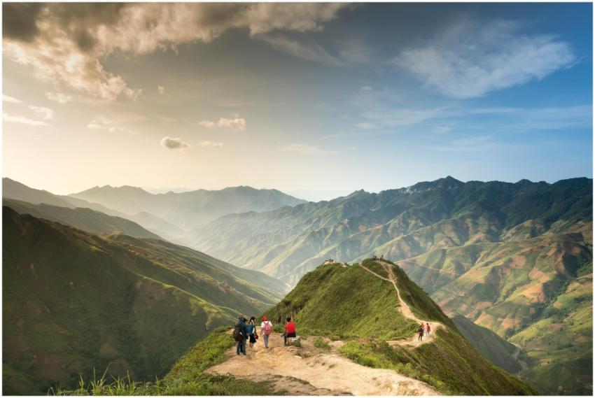 Hikers walking along a scenic mountain trail with