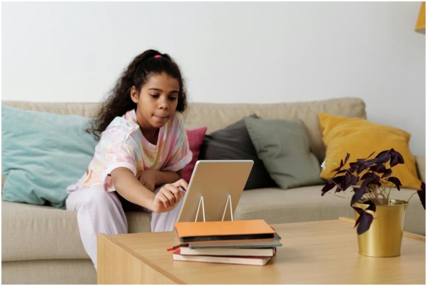 A young girl using a tablet for online learning at