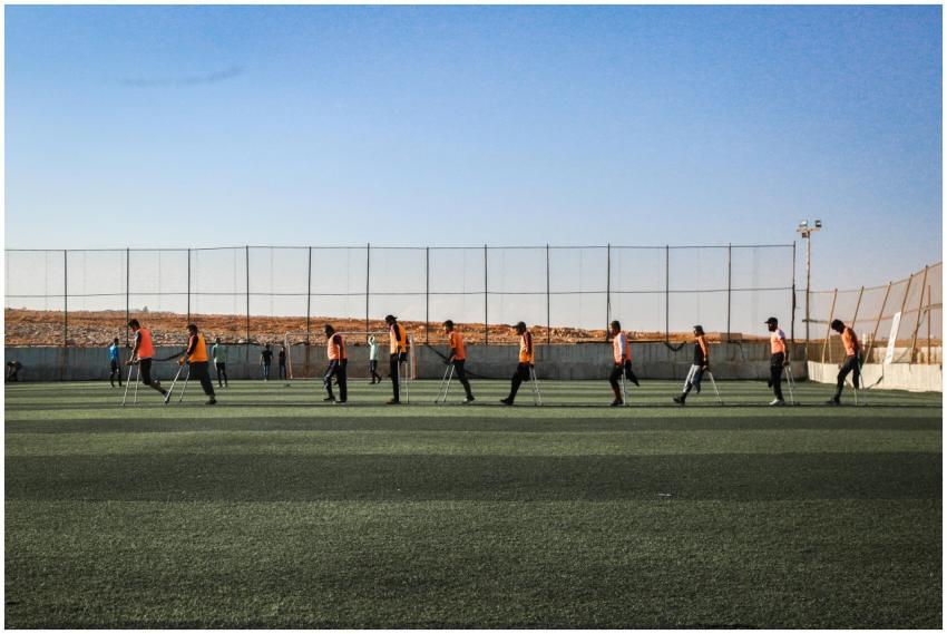 Amputee soccer players practicing on an outdoor fi